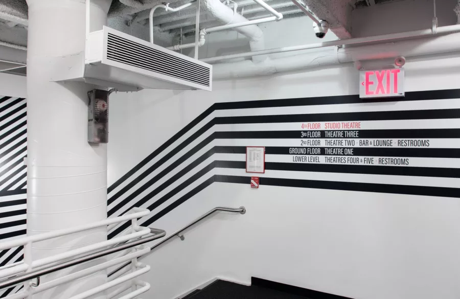 Black and white striped graphic on wall with wayfinding language.