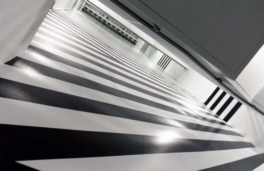 Looking up at 4 floors of a black and white striped vinyl wall graphic.